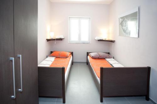 two beds in a small room with a window at Villa Marijeta Hvar in Hvar