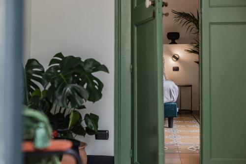 a hallway with a green door and a person sitting in a chair at Palazzo Villelmi in Cefalù