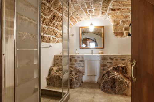 a bathroom with a glass shower and a sink at Casa tradizionale Goulas in Monemvasia