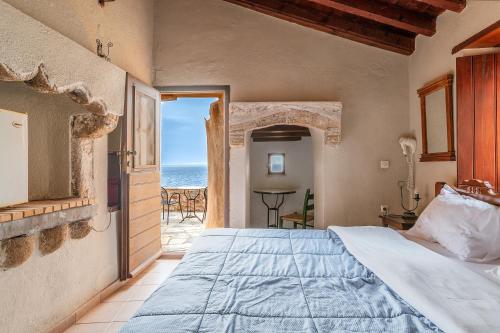 a bedroom with a bed and a view of the ocean at Casa tradizionale Goulas in Monemvasia