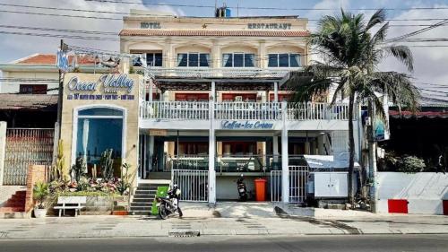 ムイネーにあるPay Ocean Valley Hotelの前にヤシの木がある建物