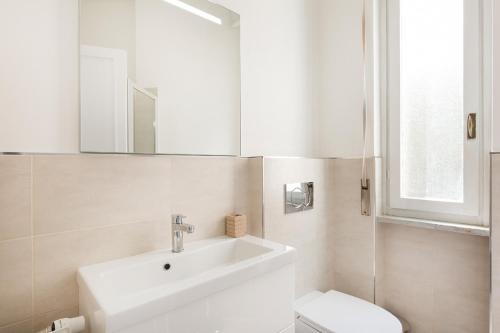 ein weißes Bad mit einem Waschbecken und einem WC in der Unterkunft Costa Azzurra by Impero House in Stresa