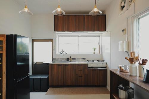 a kitchen with wooden cabinets and a sink and a window at 塩釜バケーションレンタル Sora No Oka in Shiogama