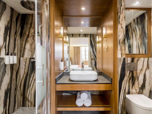 une salle de bain avec un lavabo et des toilettes dans l'établissement Merveil - Signature Suite - Louvre - Bourse II, à Paris