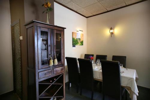 a dining room with a table with chairs and a cabinet at Hotel Rural Los Abriles in El Toro