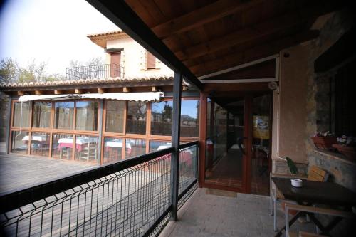 a balcony with a tennis court and a glass door at Hotel Rural Los Abriles in El Toro