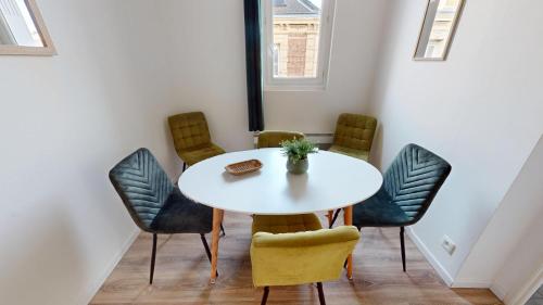 Cette chambre comprend une table et des chaises blanches. dans l'établissement Magnifique appartement Bastion, au Havre