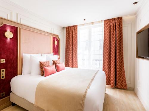 une chambre avec un grand lit blanc avec des oreillers roses dans l'établissement Merveil - Signature Suite - Marais - Archives II, à Paris