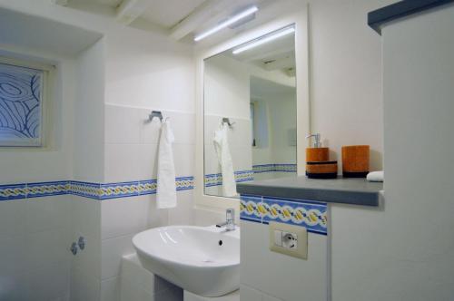 a white bathroom with a sink and a mirror at casagreve in Greve in Chianti