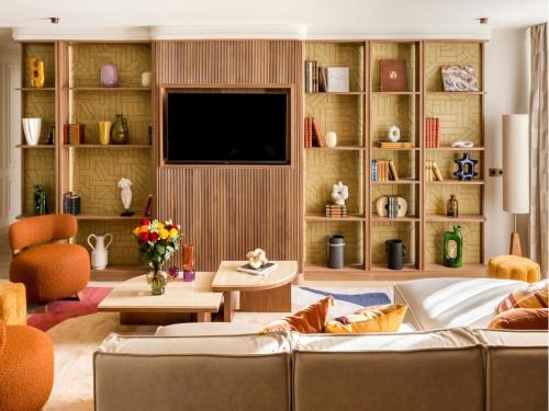 un salon avec un canapé et une télévision dans l'établissement Merveil - Signature Suite - Marais - Archives II, à Paris