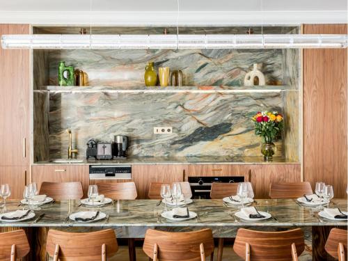 une salle à manger avec une grande table et des chaises dans l'établissement Merveil - Signature Suite - Marais - Archives II, à Paris