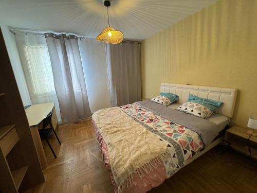 une chambre avec un lit, une table et une lampe dans l'établissement BEL APPARTEMENT Standing, à Limoges