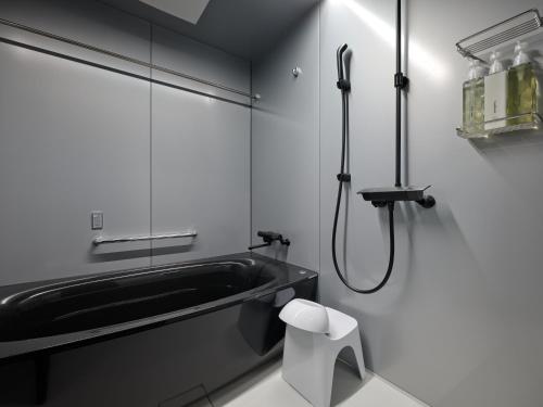 a bathroom with a bath tub and a sink at GRAND MONday GINZA in Tokyo