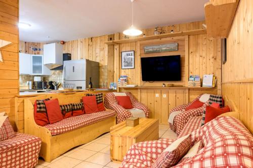 un salon avec des canapés et une télévision à écran plat dans l'établissement Gîte des Sapins, à La Bresse