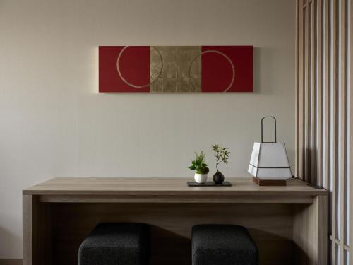 a table with two chairs and a painting on the wall at GRAND MONday GINZA in Tokyo