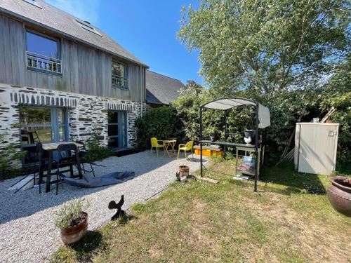 a backyard of a house with a table and chairs at Casquets - Chambre randonneur GR223 - Quai des Ormes in Barneville-Carteret