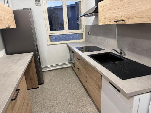 une cuisine avec un évier et un plan de travail dans l'établissement BEL APPARTEMENT Standing, à Limoges