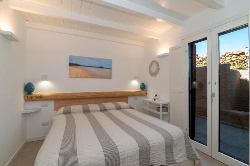 ein Schlafzimmer mit einem Bett und einem großen Fenster in der Unterkunft Villa Cactus, Costa Corallina in Olbia