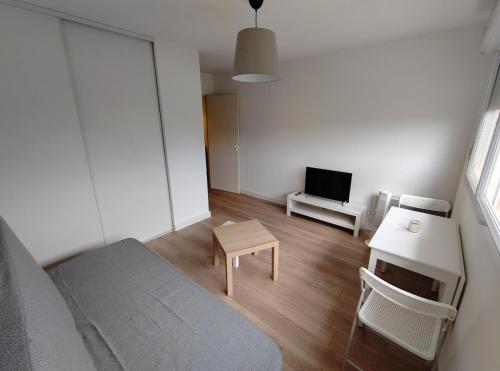 - un salon avec un lit, une table et une télévision dans l'établissement Studio proche remparts, à Avignon