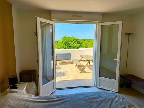 une chambre avec une porte ouverte sur un patio dans l'établissement La terrasse des Marais, à Dolus-d'Oléron