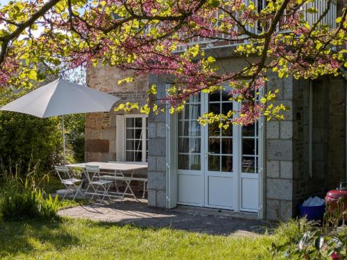 a table and an umbrella in front of a house at La Jeannette in Vains