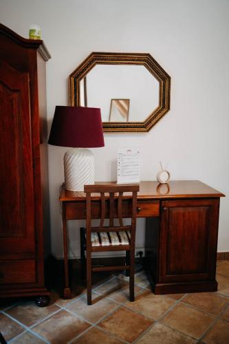 a desk with a lamp and a chair and a mirror at Tenuta Le Tre Rose in Vibonati