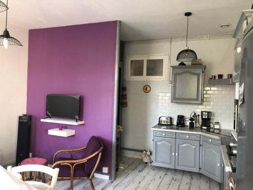 サン・ピエール・ドレロンにあるPort La Cotinière 100m plage et commercesの紫の壁のキッチン(テーブル、椅子付)