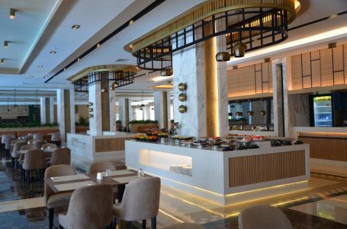 un ristorante con bar, tavoli e sedie di Sunland Resort Beldibi a Beldibi