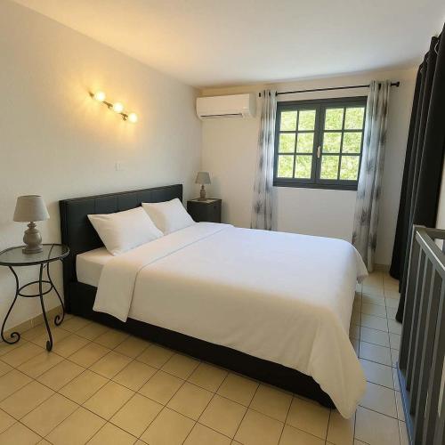 Appartement calme proche du centre في Santa-Reparata-di-Balagna: غرفة نوم بها سرير أبيض كبير ونافذة