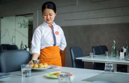 a woman standing in front of a table with a plate of food at Zone Connect by The Park Coimbatore in Coimbatore