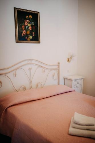 a bedroom with a bed with orange sheets and a painting on the wall at Tenuta Le Tre Rose in Vibonati