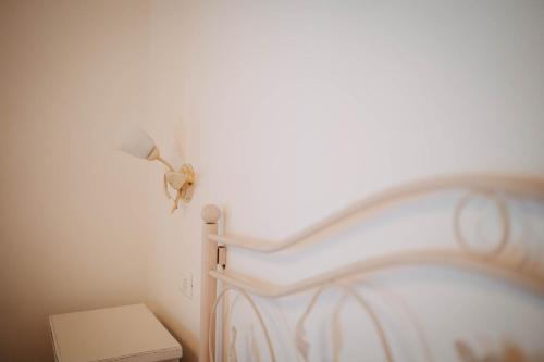 a white bed with a lamp on the wall at Tenuta Le Tre Rose in Vibonati
