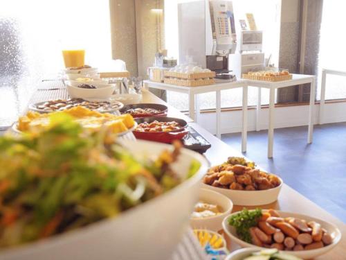 a buffet line with different types of food on a table at Hotel Areaone Miyazaki in Miyazaki