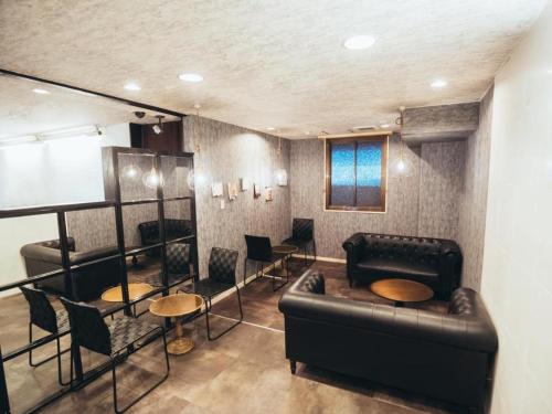 a living room with a couch and a table and chairs at Hotel Areaone Miyazaki in Miyazaki