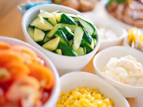 a table topped with bowls of vegetables and other foods at Hotel Areaone Miyazaki in Miyazaki