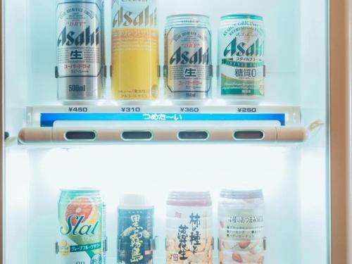 a refrigerator filled with cans and bottles of drinks at Hotel Areaone Miyazaki in Miyazaki