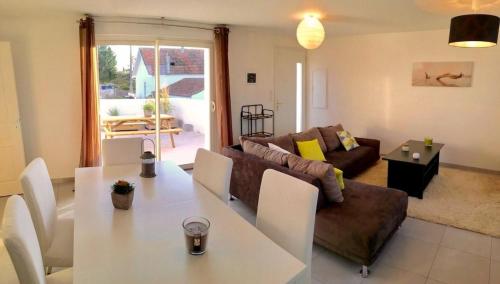 un salon avec une table et un canapé dans l'établissement La terrasse des Marais, à Dolus-d'Oléron