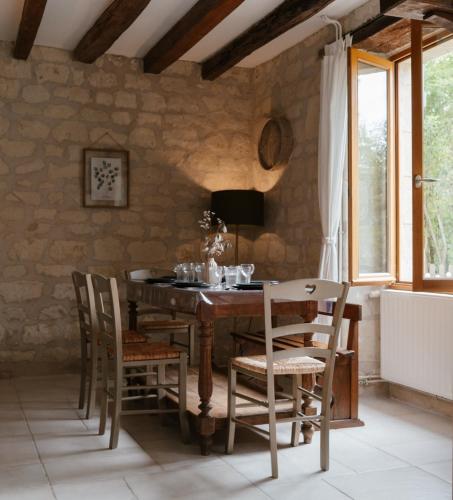 une salle à manger avec une table et des chaises en bois dans l'établissement Gîte Les Caves aux Fièvres - Maison avec jardin près de Chinon, à Beaumont-en-Véron