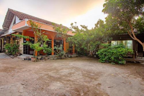 a house with a lot of trees in front of it at Super OYO 1788 House 24 in Yogyakarta
