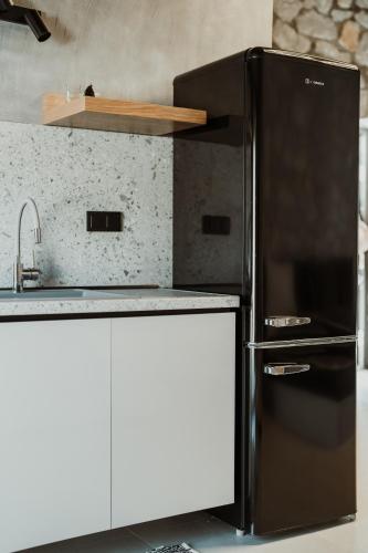 a kitchen with a black refrigerator and a sink at Ktima Papadopoulou in Krionérion