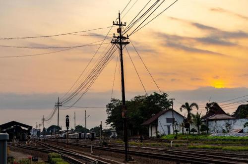 a set of train tracks with a sunset in the background at Super OYO 1788 House 24 in Yogyakarta