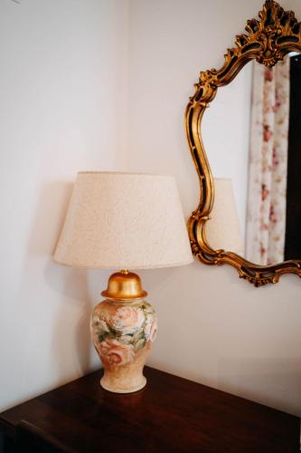 a lamp sitting on a table next to a mirror at Tenuta Le Tre Rose in Vibonati