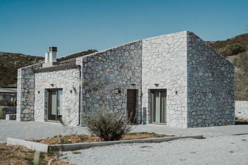 a stone house with a stone wall at Ktima Papadopoulou in Krionérion
