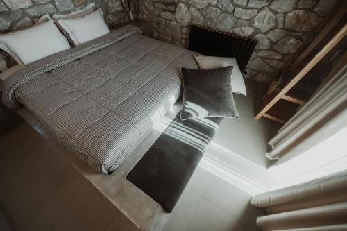 a large bed in a room with a stone wall at Ktima Papadopoulou in Krionérion