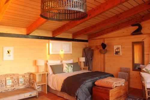 a bedroom with a bed in a log cabin at Freefall Cottage in Haumoana