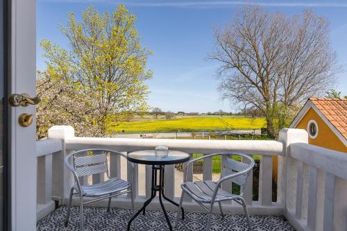 a table and two chairs on a balcony with a view at Mjällbyhus Pensionat & Stugby in Sölvesborg