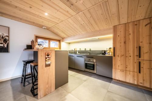 - une cuisine avec des plafonds en bois et des placards en bois dans l'établissement COUTETTAZ 1 Joli 2 chambres idéalement situé dans Morzine, à Morzine