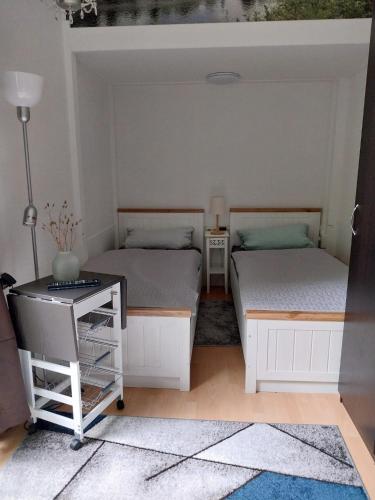 two beds in a room with a table and a desk at Apartment zum Garten in Nienburg