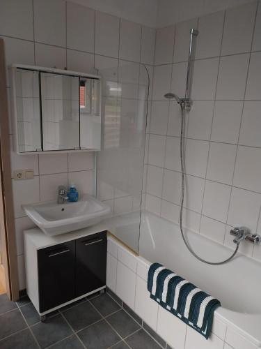 a bathroom with a tub and a sink and a shower at Apartment zum Garten in Nienburg