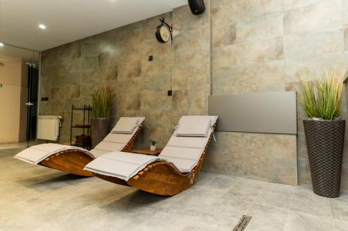 a room with two lounge chairs and a stone wall at Hotel DEMETRA in Berkovitsa